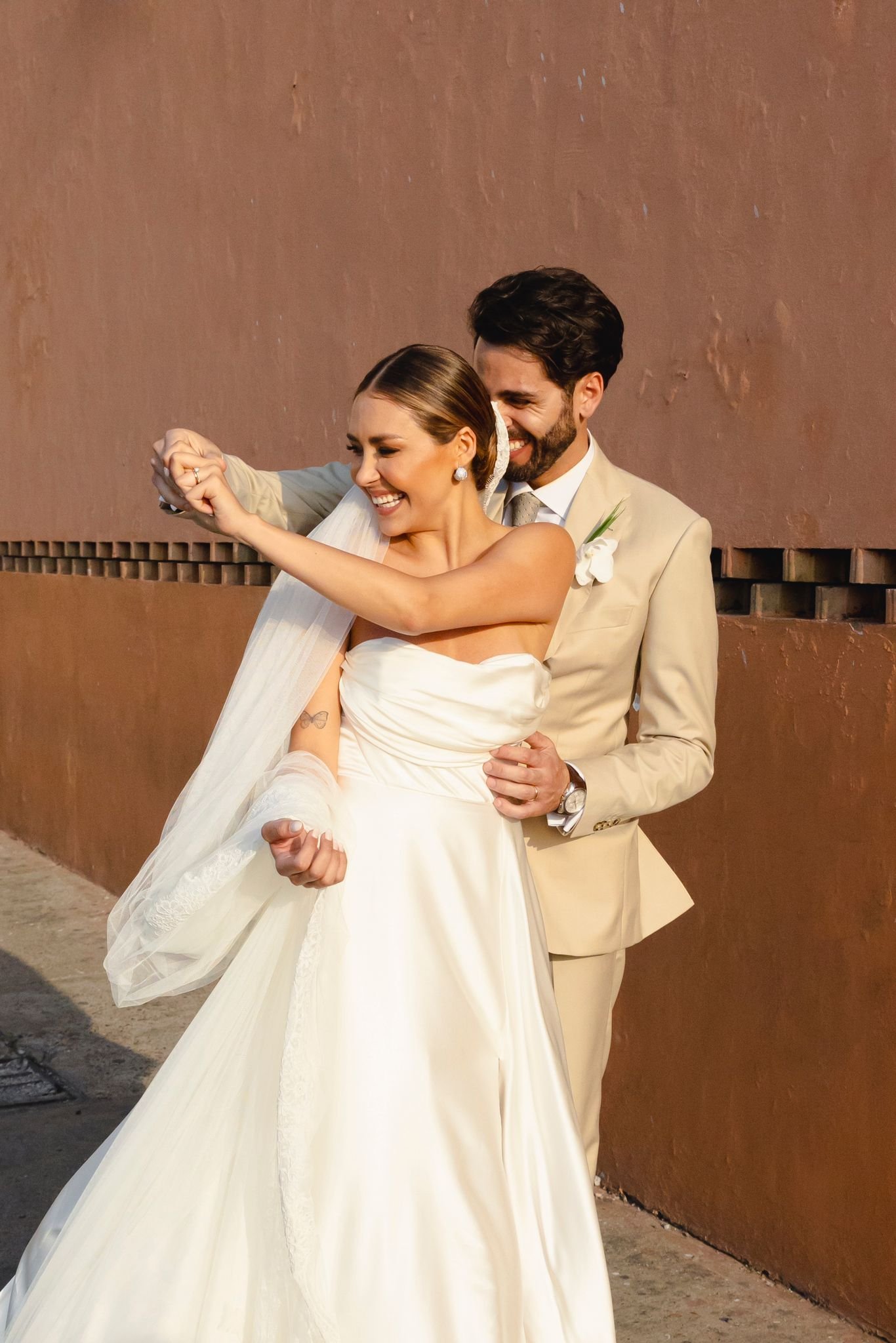 Antonella y su marido bailando juntos frente a la pared de terracota colonial