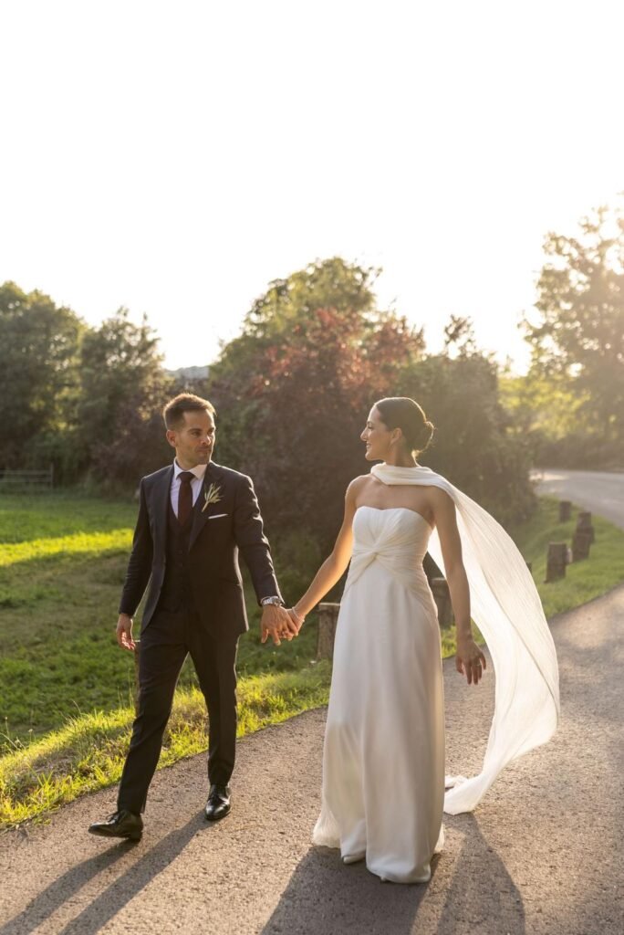 Eisel y su pareja al atardecer en los jardines de Mas Marroch, vestido de novia de bambula de seda plisada con banda drapeada a un hombro