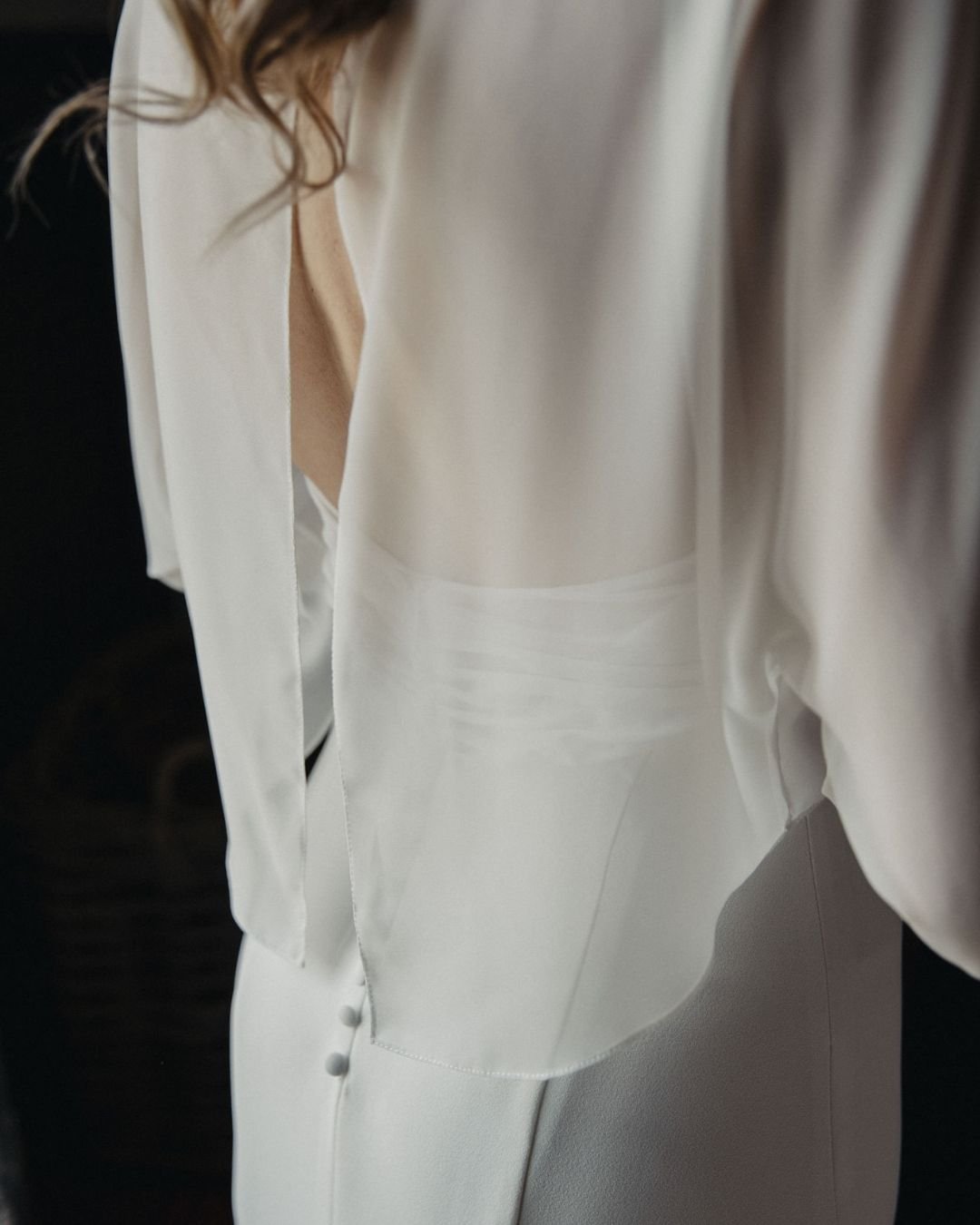 Detalle de la chaqueta de gasa sobre el vestido de crepé, con botones forrados