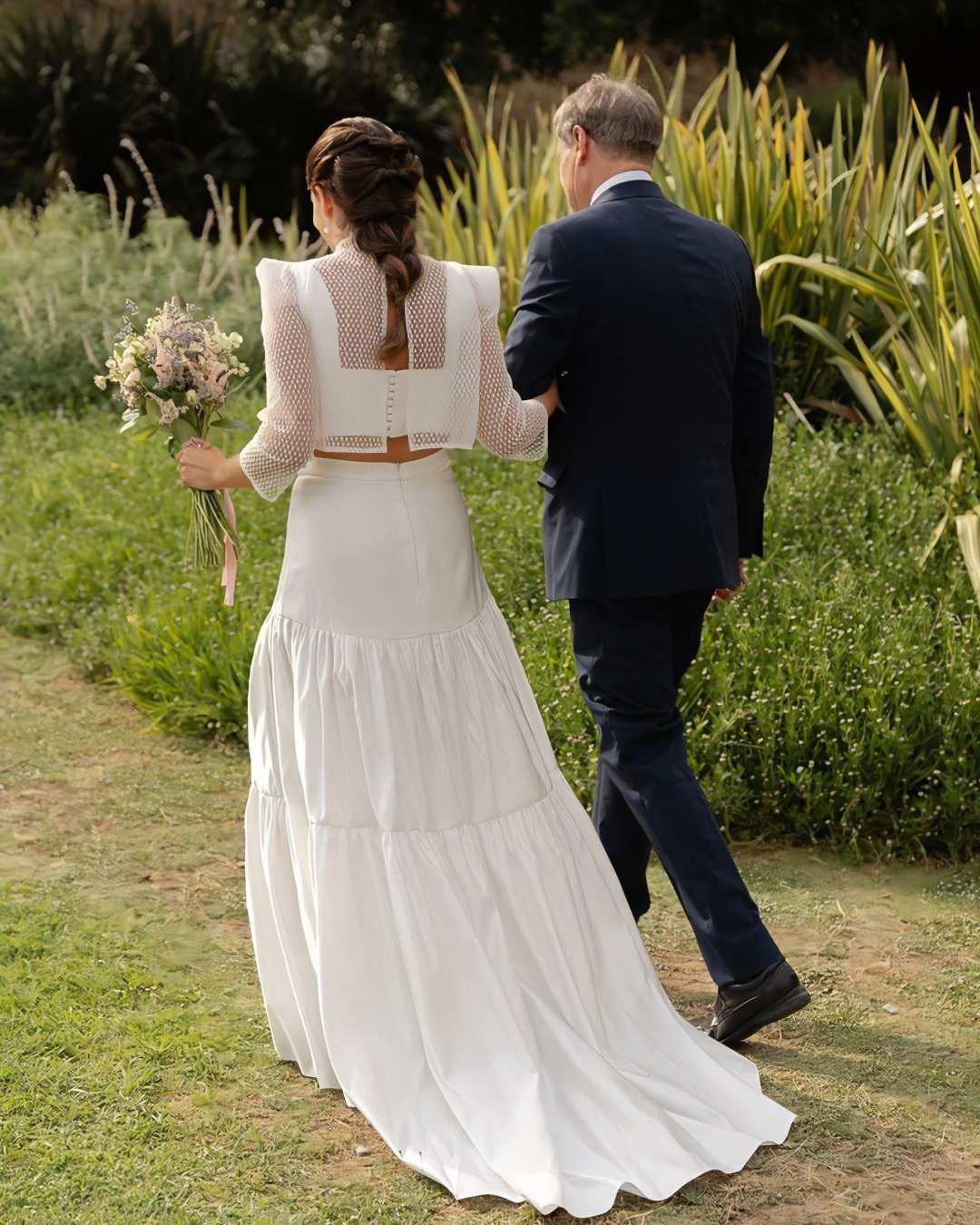 Espalda del look de novia de Laura: chaqueta corta de tul bordado geométrico sobre cuerpo y falda de mikado de seda