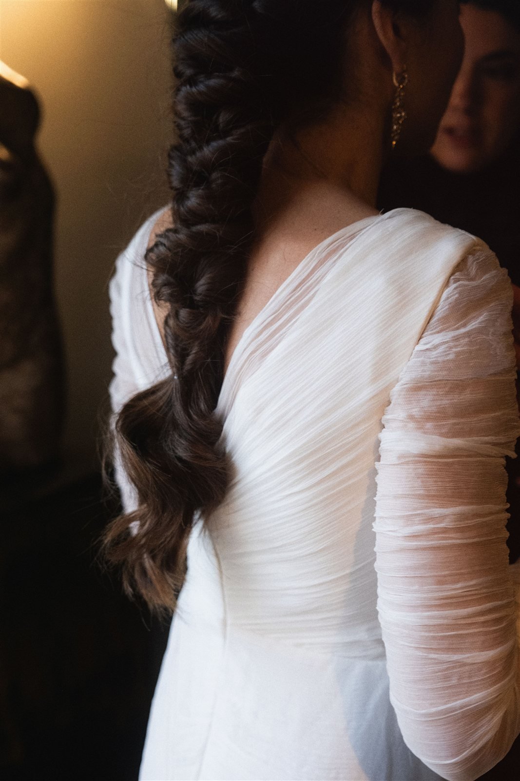 Espalda en pico del vestido de María con las mangas de bambula plisada