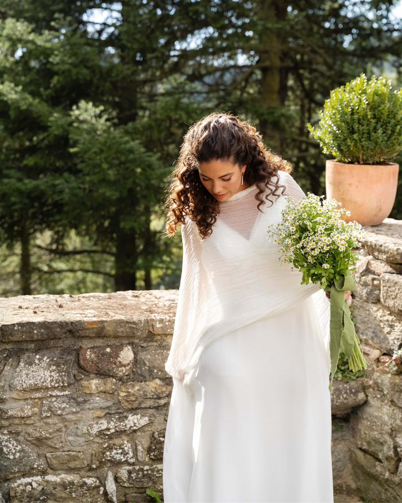 Marina con vestido de gasa de seda y foulard plisado junto al muro de piedra de la Masia El Collell