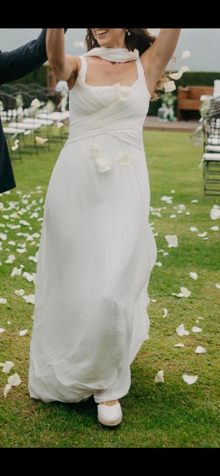 Mireia a la salida de la ceremonia entre pétalos, vestido de gasa de seda