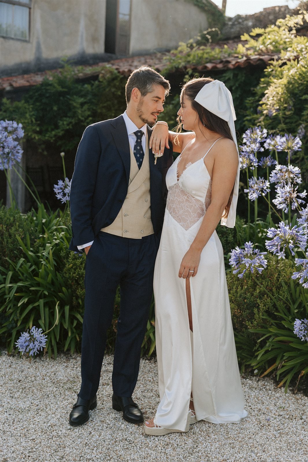 Nina e Iago en el jardín el día de su boda en Galicia, vestido de satén de seda