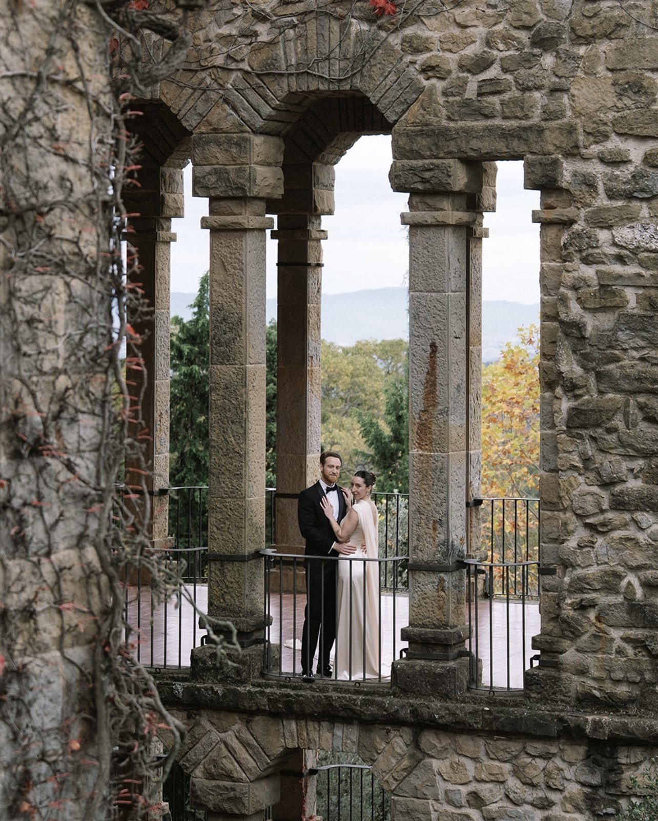 Paula y su pareja en la galería de arcos de piedra de La Baronia, con vistas a la montaña